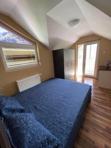 1 dormitorio con 1 cama grande con manta azul en Villa Maria, en Nižepole