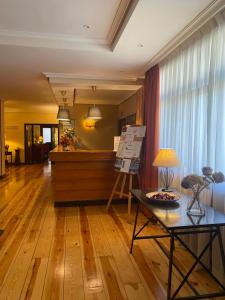 ein Wohnzimmer mit Holzböden und einem Tisch in der Unterkunft Hotel Rural Spa & Wellness Hacienda Los Robles in Navacerrada