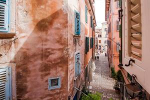 an alley between two buildings in an old town at Apartments Casa Rubeus Rovinj in Rovinj