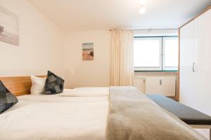 Un dormitorio con una cama grande y una ventana en Haus-Kaept-n-Hein-Cors, en Wenningstedt
