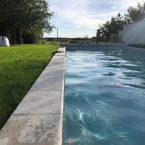 - une piscine d'eau bleue dans la cour dans l'établissement Gabaë, Gîte 3 personnes, jardin et piscine, à Puyravault