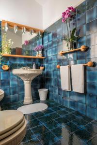 Baño de azulejos azules con aseo y lavamanos en Umbria Country B&B, en Giove