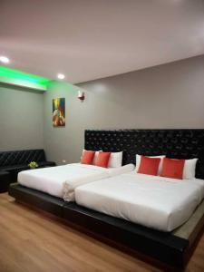 - une chambre avec 2 lits dotés d'oreillers rouges et blancs dans l'établissement Sawasdee​ Buriram​ Resort, à Buriram