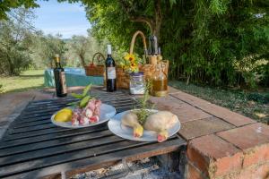 una mesa con dos platos de comida y botellas de vino en Umbria Country B&B, en Giove