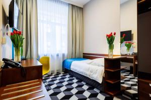 Pokój hotelowy z łóżkiem i biurkiem z kwiatami w obiekcie Hotel Wyspiański w Krakowie +37 zdjęć