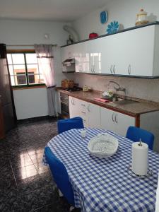 een keuken met een tafel met een blauw en wit tafelkleed bij Arenas del mar in La Mareta