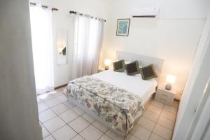 ein weißes Schlafzimmer mit einem Bett und zwei Lampen in der Unterkunft Nirachel Ltd in Belle Mare