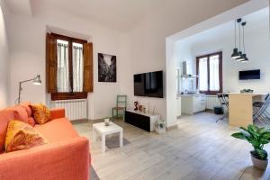 a living room with a orange couch and a table at Mamo Florence - Baldovini Apartment in Florence