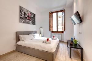 a small bedroom with a bed and a television at Mamo Florence - Baldovini Apartment in Florence