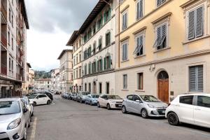 una fila de autos estacionados en una calle al lado de edificios en Baldovini Apartment by Mamo Florence, en Florencia