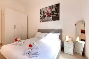 1 dormitorio con 1 cama blanca y 1 autobús de 2 pisos en Baldovini Apartment by Mamo Florence, en Florencia