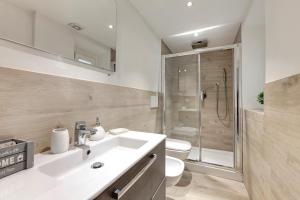 Un baño con lavabo, inodoro y ducha. en Baldovini Apartment by Mamo Florence, en Florencia 17 fotos más