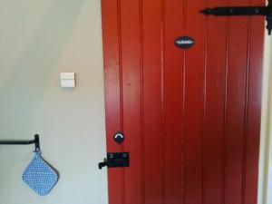 uma porta vermelha no canto de um quarto em vakantiewoning 't Bakhuus em Bergentheim