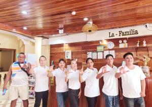 a group of people holding their hands up in a room at La-Familia Guest House in Siquijor
