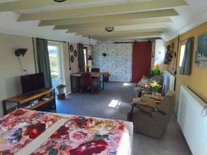 um quarto com uma cama e uma sala de estar em vakantiewoning 't Bakhuus em Bergentheim