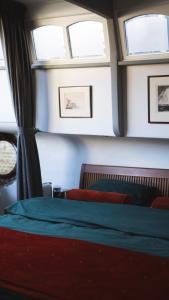 - une chambre avec deux fenêtres et un lit avec des draps verts dans l'établissement Amsterdam Center - Houseboat B&B by Captain Ricard, à Amsterdam