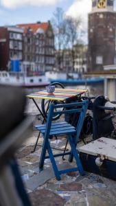 une table et une chaise bleue avec une planche de surf dans l'établissement Amsterdam Center - Houseboat B&B by Captain Ricard, à Amsterdam