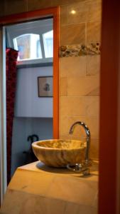La salle de bains est pourvue d'un lavabo et d'un bol en pierre. dans l'établissement Amsterdam Center - Houseboat B&B by Captain Ricard, à Amsterdam