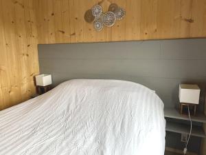 a bedroom with a white bed with two lights on it at Sunny view Egmond in Egmond-Binnen