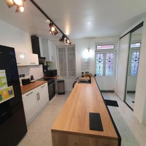 een grote keuken met een lang houten aanrecht bij La maison des galeries classé 4 étoiles in Fécamp