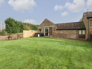 a house with a yard with a picnic table and a bench at Peartree Cottage in Worcester