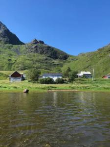 zbiornik wodny z domami i górami w tle w obiekcie Charming house in fjord Lofoten 