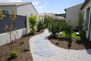 ogród z kamieniami i drzewami oraz ogrodzeniem w obiekcie Maison chaleureuse en Provence w mieście Piolenc