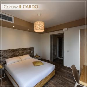 a bedroom with a large white bed and a chandelier at Casale Ermo Colle in San Filippo