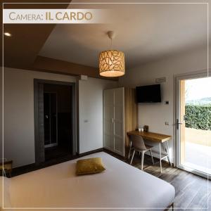 een slaapkamer met een bed, een tafel en een lamp bij Casale Ermo Colle in San Filippo