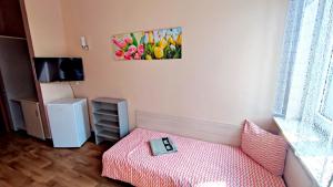 a small room with a bed with a pink blanket at Pokoje Gościnne Rozbark in Bytom