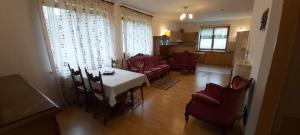 ein Wohnzimmer mit einem Tisch und roten Stühlen in der Unterkunft Villa Gejzir 34 in Karlsbad
