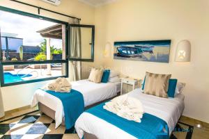 2 łóżka w pokoju z widokiem na basen w obiekcie Casa Bonita - LH144 By Villas Now Ltd w mieście Playa Blanca +37 zdjęć