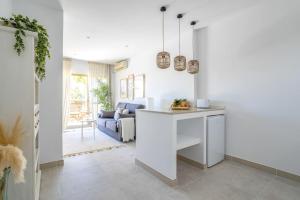 una cucina e un soggiorno con pareti bianche e tavolo di OleHolidays 726 Romana Playa junto al mar a Marbella
