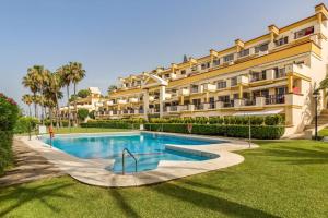 un resort con piscina di fronte a un edificio di OleHolidays 726 Romana Playa junto al mar a Marbella
