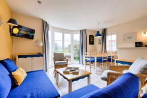 a living room with a blue couch and a table at Residence Port Bourgenay - maeva Home in Talmont
