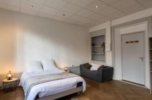 een slaapkamer met een bed en een stoel bij Résidence Harmonie Appartement N 1 Haut de gamme Avec Petit Déjeuner in Néris-les-Bains