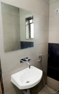 y baño con lavabo blanco y espejo. en Hotel Annapura Residency, Chalisgaon, en Chālisgaon