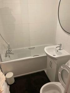 a bathroom with a tub and a toilet and a sink at Two bedroom flat in London near the 02 in London