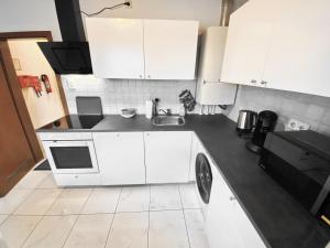 cocina con armarios blancos y encimera negra en # VAZ Apartments WU11 für Monteure Küche, TV, WLAN, Parkplatz, Autobahnähe, en Schwelm