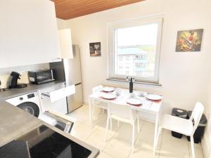 una cocina con una mesa y sillas blancas y una ventana en # VAZ Apartments WU11 für Monteure Küche, TV, WLAN, Parkplatz, Autobahnähe, en Schwelm