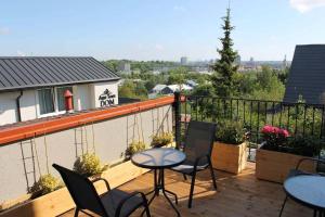 un patio con mesas y sillas en el balcón en Villa AgaTomDom, en Gdansk