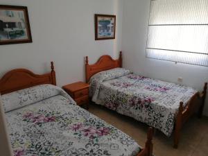 two beds in a small room with twoitures at Alojamiento las Dunas in Tabernas