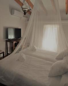 Finca Sa Cova Vella في ماناكور: سرير أبيض مع ناموسية في الغرفة