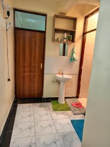 a bathroom with a toilet and a sink and a door at SAFNEST Furnished Apartment in Nakuru