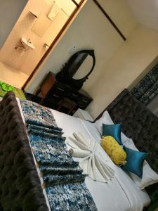 a bedroom with a bed with blue and white pillows at SAFNEST Furnished Apartment in Nakuru