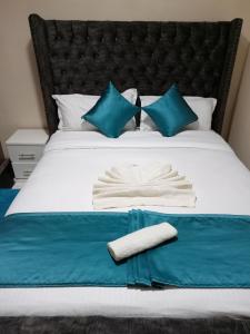 ナクルにあるSAFNEST Furnished Apartmentのベッド(青と白の枕付)