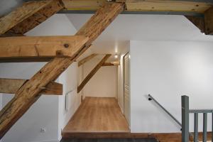 Habitación en el ático con vigas de madera y paredes blancas. en Bel appartement 2 chambres climatisé en Mont-Notre-Dame