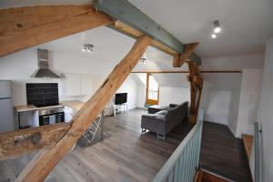 una vista aérea de una sala de estar y una cocina con vigas de madera. en Bel appartement 2 chambres climatisé en Mont-Notre-Dame
