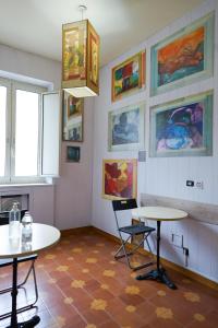 a room with two tables and paintings on the wall at Roma Room Hotel in Rome