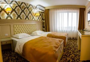 ein Hotelzimmer mit 2 Betten und einem Fenster in der Unterkunft Little Orient in Brăila